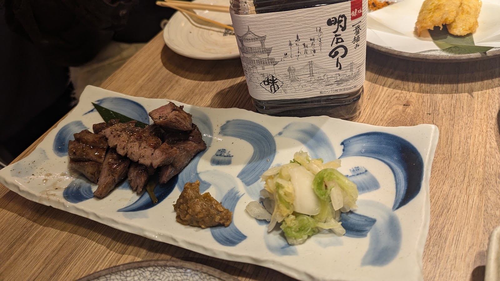 青と白の皿に、薄切りの焼いた肉が並んでいる。